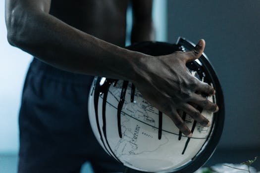 pexels-photo-7965690-7965690-1 A hand holding a globe dripping with oil, symbolizing pollution and fossil fuels.